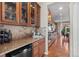Gourmet kitchen featuring wine storage, granite counters, travertine backsplash, and stainless appliances at 2776 Badlands Ct, Castle Rock, CO 80109