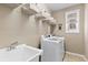 Bright laundry room featuring a sink, storage shelves, and modern appliances at 2776 Badlands Ct, Castle Rock, CO 80109