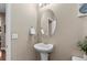 Charming powder room featuring a pedestal sink and decorative mirror at 2776 Badlands Ct, Castle Rock, CO 80109