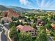 Stunning aerial view of a neighborhood nestled amongst picturesque rock formations and lush greenery with mountain views at 10751 Fairway Vistas Ct, Littleton, CO 80125