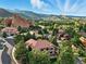 Beautiful aerial view of homes nestled amongst trees with stunning red rock formations and mountain views at 10751 Fairway Vistas Ct, Littleton, CO 80125