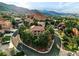 Panoramic aerial view of the home and neighborhood surrounded by red rocks and mountains at 10751 Fairway Vistas Ct, Littleton, CO 80125