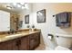 Bathroom featuring granite countertops, vanity with dark wood cabinets, a large mirror, and modern fixtures at 10751 Fairway Vistas Ct, Littleton, CO 80125