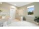 Bright bathroom featuring white tile flooring, gold-trimmed shower and a large window view at 10751 Fairway Vistas Ct, Littleton, CO 80125