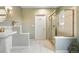Bright bathroom featuring white tile flooring, gold-trimmed shower and a pedestal sink at 10751 Fairway Vistas Ct, Littleton, CO 80125