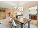 Bright dining room features modern chandelier and a large wooden table with seating for six at 10751 Fairway Vistas Ct, Littleton, CO 80125
