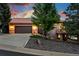 Inviting home with a two-car garage, large driveway, mature landscaping, and charming architectural details at 10751 Fairway Vistas Ct, Littleton, CO 80125