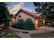 Charming home boasts a two-car garage, mature trees, a tile roof, and a lush, landscaped yard at 10751 Fairway Vistas Ct, Littleton, CO 80125