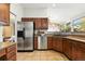 Functional kitchen featuring stainless steel appliances, wooden cabinetry, and tile flooring at 10751 Fairway Vistas Ct, Littleton, CO 80125