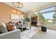 Open living room with stone fireplace, large windows offering scenic views, and comfortable seating at 10751 Fairway Vistas Ct, Littleton, CO 80125