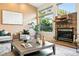Cozy living room featuring a brick fireplace, large windows, and stylish decor at 10751 Fairway Vistas Ct, Littleton, CO 80125