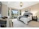Inviting main bedroom showcases large bay windows, plush carpet, ample natural light, and decorative chandelier at 10751 Fairway Vistas Ct, Littleton, CO 80125