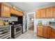 Functional kitchen with stainless steel appliances, wooden cabinets, and tile flooring at 4326 Batavia Pl, Denver, CO 80220