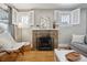 Cozy living room with a brick fireplace, hardwood floors, and bright windows at 4326 Batavia Pl, Denver, CO 80220