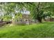 Spacious backyard with grassy lawn, patio, and mature trees providing ample shade for outdoor enjoyment at 1440 E 128Th Ct, Thornton, CO 80241