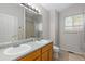 Bathroom features a double sink vanity, neutral colors, and window with natural light at 1440 E 128Th Ct, Thornton, CO 80241