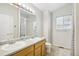 Bright bathroom featuring double sinks, natural light, and shower with neutral finishes at 1440 E 128Th Ct, Thornton, CO 80241