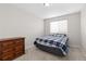 Carpeted bedroom with window, bed with plaid comforter, and dresser at 1440 E 128Th Ct, Thornton, CO 80241