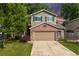 Charming two-story home with a brick facade and well-maintained lawn and mature trees at 1440 E 128Th Ct, Thornton, CO 80241
