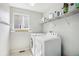 Efficient laundry room with modern washer and dryer units and shelving for storage at 1440 E 128Th Ct, Thornton, CO 80241