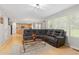 Spacious living room with hardwood floors, a large sectional sofa, and open kitchen access at 1440 E 128Th Ct, Thornton, CO 80241
