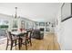 Open-concept living area with hardwood floors, dining table, and a cozy seating area with a fireplace at 1440 E 128Th Ct, Thornton, CO 80241