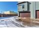 Modern home featuring a brown garage door, sleek architecture, and a snowy driveway at 2114 N Clay St, Denver, CO 80211