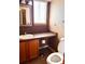 A half-bathroom featuring a toilet, a vanity, and a decorative mirror at 10064 Westside Cir, Littleton, CO 80125