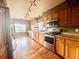 Well-lit kitchen with stainless steel appliances, wood cabinets, and hardwood floors at 10064 Westside Cir, Littleton, CO 80125