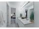 Bright bathroom featuring double sinks, neutral tile, and a view into the adjacent bedroom at 2875 S Tower Way, Aurora, CO 80013