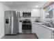Well-equipped kitchen featuring stainless steel appliances and white cabinetry at 2875 S Tower Way, Aurora, CO 80013