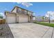 Two-story house with neutral siding, three-car garage, and a landscaped lawn at 13547 Valentia St, Thornton, CO 80602
