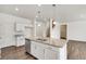 Modern kitchen with island, white cabinets, and stainless steel appliances at 13547 Valentia St, Thornton, CO 80602