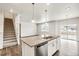 Modern kitchen with island, white cabinets, and stainless steel appliances at 13547 Valentia St, Thornton, CO 80602