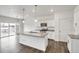 Modern kitchen with white cabinets, granite counters, and island at 13547 Valentia St, Thornton, CO 80602