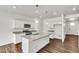 Modern kitchen with white cabinets, granite counters, and island at 13547 Valentia St, Thornton, CO 80602