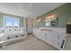 Elegant bathroom featuring a bathtub, tiled floor, and walk-in shower and double vanity at 21166 E Euclid Dr, Centennial, CO 80016