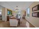 Cozy dining room with a tray ceiling, modern chandelier, hardwood floors, and natural light at 21166 E Euclid Dr, Centennial, CO 80016