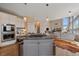 Open layout showing the kitchen with stainless steel appliances and island, connected to other living spaces in the home at 21166 E Euclid Dr, Centennial, CO 80016