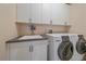 Convenient laundry room featuring a sink, cabinetry, and modern washer and dryer at 21166 E Euclid Dr, Centennial, CO 80016