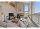 Bright living room boasts a fireplace, high ceilings, and large windows, creating a warm and inviting atmosphere at 21166 E Euclid Dr, Centennial, CO 80016