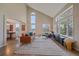 Open-concept living room with large windows, vaulted ceilings, a leather sofa, and hardwood floors at 21166 E Euclid Dr, Centennial, CO 80016