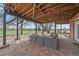A covered patio with a woven sofa and exposed wood beams creates a great space for outdoor living at 21166 E Euclid Dr, Centennial, CO 80016