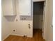 Utility room with laminate flooring, white cabinets, and access to another bathroom at 667 W Valleyview Ave, Littleton, CO 80120