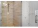 Modern walk-in shower featuring light stone-look tile, glass doors, and rainfall shower head at 3050 Wilson Ct # 1, Denver, CO 80205