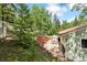 Serene backyard featuring a brick wall, patio with dining set, and lush greenery, offering privacy and tranquility at 7256 Aspen Meadow Dr, Evergreen, CO 80439