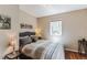 Comfortable bedroom with a tufted headboard, hardwood floors, and ample natural light from the window at 7256 Aspen Meadow Dr, Evergreen, CO 80439