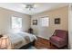 Bright bedroom with hardwood floors, two windows, and comfortable furniture, offering a peaceful retreat at 7256 Aspen Meadow Dr, Evergreen, CO 80439