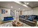 Cozy basement area with comfortable seating, textured rug, blue accents, and decorative wall art at 6471 S Potomac Ct, Englewood, CO 80111