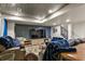 Finished basement with entertainment area, large screen TV, comfortable seating, and decorative ceiling at 6471 S Potomac Ct, Englewood, CO 80111